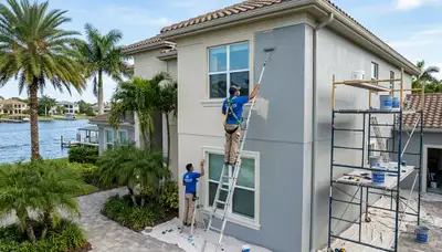 Professional house painters working on exterior home repaint in Cape Coral FL